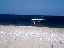 Pregnant nudist woman at beach
