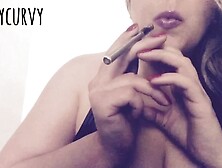 Blonde Carlycurvy vaping and playing in a short leather dress