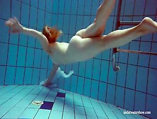 Redhead goes for a nude swim in the pool