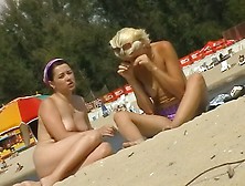 Two Topless Girls Sunbathing In Front Of A