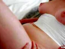 Hazel Moore and Melody Marks on a grey and white bed in lesbian dildo scenes together