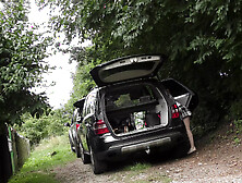 Hot redhead in short skirt loads a car