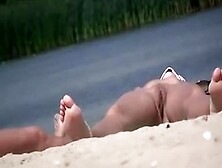 Nudist Sunbathing In River Shore