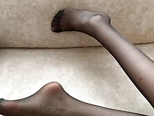 Girl in black stockings caresses her long legs