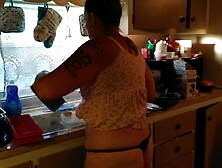Showing off my cleavage and belt by lifting up my costume whilst cooking in kitchen