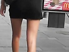 Hot tanned brunette chick walks on a busy street sidewalk upskirt