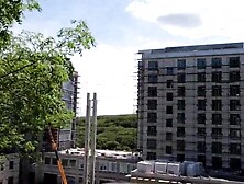 An exhibitionist GIRL walks on a construction site