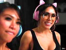 Ember Snow and Jena Larose on a black coloured leather sofa in a lesbian scene