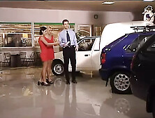 Two Girls in Red Dresses Have Fun at the Car Dealer