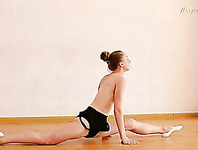 Blonde ballerina stretches and bends in the nude