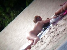 Nude blonde babe sunbathing at the beach and caught on cam