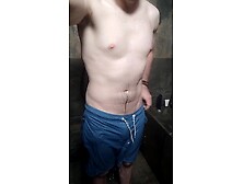 Je me masturbe sous la douche en short de bain et fait grossir ma grosse bite toute mouillée.