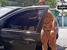 Mulher sensuous lava o carro se exibindo publicamente na rua.