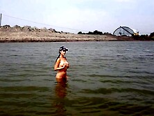 Naked girl masturbates on the river shore