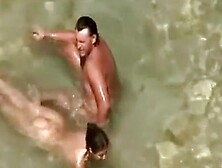 Nudist Couple In Water At Beach