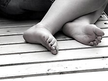 Women's Feet On A Park Bench.