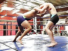 Young Wrestler Wearing Black,  Blue And White Spandex Wrestles In The Ring With His Hunk Opponent In Violet Spandex Before He Wan