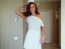 Cute brown haired babe poses seductively in a sexy white dress