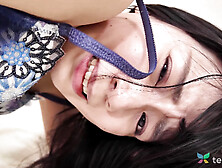 Japanese woman Mikoto Fujisaki plays with a sex toy in bed.