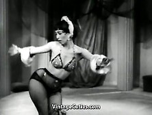 Captivating Brunette Wearing Satin Head Piece And Dress Undresses Herself On A Stage While Dancing