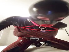 Latex Covered And Caged Guy Takes On A Fucking Machine